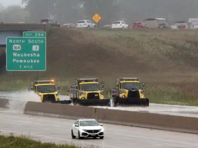 Three highway operations plows pushing flood waters off of state trunk highway 94